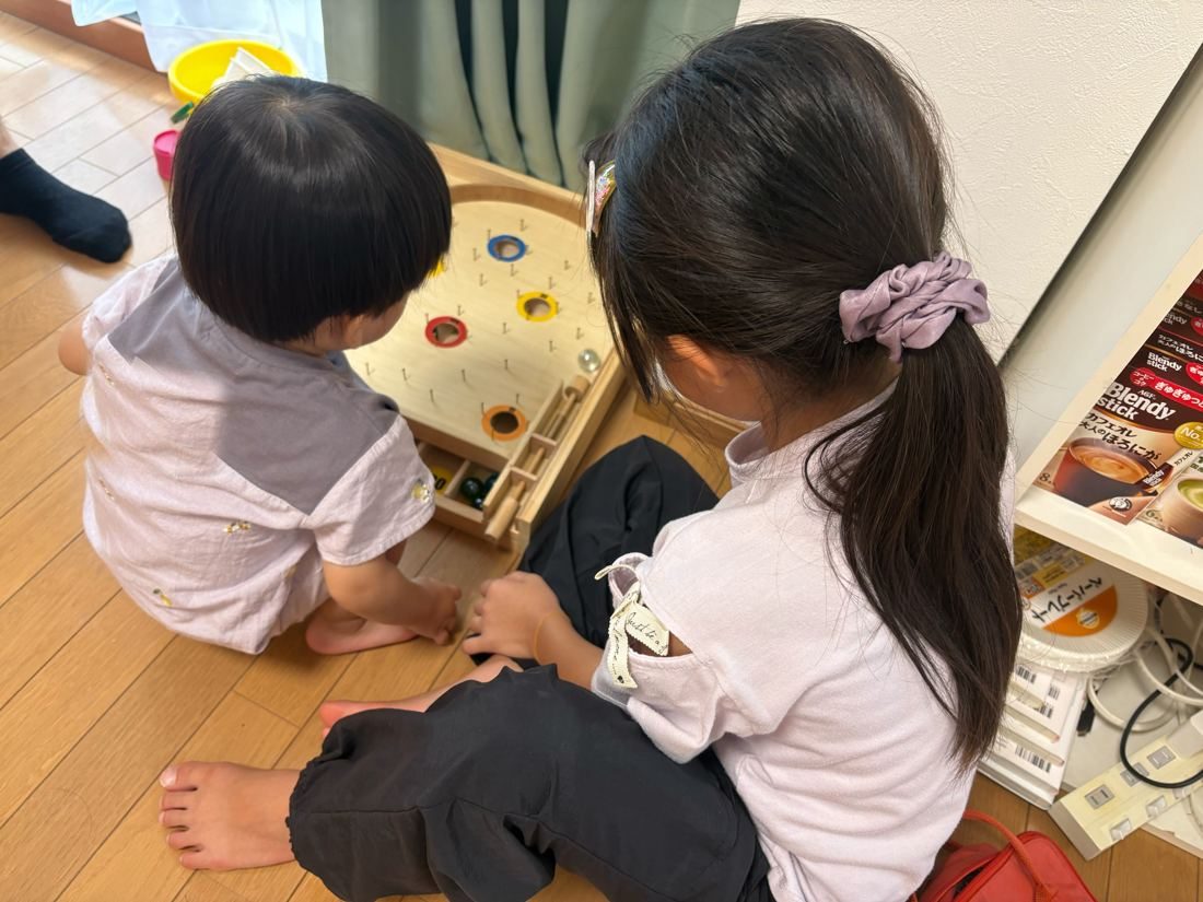 木のおもちゃで遊ぶ二人の子ども